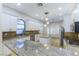 Modern kitchen featuring granite countertops, white cabinets, stainless steel appliances, and stylish pendant lighting at 379 Marlin Cove Rd, Henderson, NV 89012