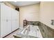 Bathroom features a built-in bathtub with stone surround and white cabinets at 3930 Maranatha Cir, Las Vegas, NV 89103