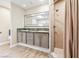 Bright bathroom features a double sink vanity with shower and wood-look floors at 3930 Maranatha Cir, Las Vegas, NV 89103