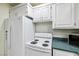 A functional kitchen featuring white appliances, laminate countertops, and a cozy, efficient layout at 3930 Maranatha Cir, Las Vegas, NV 89103