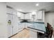 A compact kitchen with white cabinets, laminate countertops, and appliances; an efficient design for easy meal preparation at 3930 Maranatha Cir, Las Vegas, NV 89103