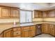 Bright kitchen featuring granite countertops, a stainless steel dishwasher, and wooden cabinetry at 3930 Maranatha Cir, Las Vegas, NV 89103