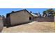 Backyard of home with block wall fence, concrete patio, dirt ground, and part of building shown at 4041 Saguaro Ln, Las Vegas, NV 89110
