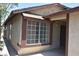 View of the front of a stucco home with brown trim and large bright window at 4041 Saguaro Ln, Las Vegas, NV 89110