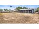 Large backyard with a covered patio extending from the house, surrounded by a block wall at 408 Bolsa Dr, Las Vegas, NV 89110