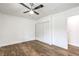 Cozy bedroom with wood-look flooring, a ceiling fan, and a closet with sliding doors for storage at 408 Bolsa Dr, Las Vegas, NV 89110