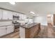 Modern kitchen featuring white cabinets, stainless steel appliances, and an island with a unique wood accent design at 408 Bolsa Dr, Las Vegas, NV 89110