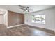 Bright living room featuring sleek wood-look floors, stylish wood accent wall, and a modern ceiling fan at 408 Bolsa Dr, Las Vegas, NV 89110