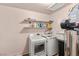 Functional laundry room equipped with a washer, dryer, shelving, and water softener at 4201 Sunrise Ave, Las Vegas, NV 89110
