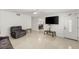 Light filled living room with tile floors, a large TV, front door, and dining area at 4201 Sunrise Ave, Las Vegas, NV 89110