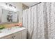 Cozy bathroom with vanity, framed mirror, decorative shelves, and a shower with floral curtain at 4606 Powell Ave, Las Vegas, NV 89121