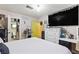 Bedroom with a large TV, a white dresser, a vanity area, and an adjacent bathroom at 4606 Powell Ave, Las Vegas, NV 89121