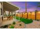 Backyard featuring an outdoor seating area, artificial grass, and manicured landscaping at 4856 Fiesta Lakes St, Las Vegas, NV 89130