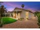 Home exterior featuring a covered patio with seating, artificial grass, and well-kept landscaping at 4856 Fiesta Lakes St, Las Vegas, NV 89130