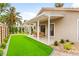 The home has a covered patio overlooking a synthetic grass lawn with desert landscaping; ready for outdoor enjoyment at 4856 Fiesta Lakes St, Las Vegas, NV 89130