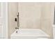 Bright bathroom featuring beige tile walls, black hardware, and a white tub at 4856 Fiesta Lakes St, Las Vegas, NV 89130