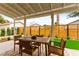 The covered patio includes wood furniture and has a great view of the back yard, with synthetic grass at 4856 Fiesta Lakes St, Las Vegas, NV 89130