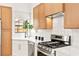 Close-up of a bright, modern kitchen with stainless steel appliances, white countertops, and wood cabinetry at 4856 Fiesta Lakes St, Las Vegas, NV 89130