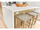 Close-up of the kitchen island with white countertops and woven bar stools at 4856 Fiesta Lakes St, Las Vegas, NV 89130