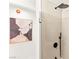 Close-up of a shower with black fixtures, beige tiles, and a rain shower head at 4856 Fiesta Lakes St, Las Vegas, NV 89130