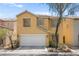 Two-story home with a two-car garage, desert landscaping, and a tile roof at 5674 Moccasin Point St, Las Vegas, NV 89148