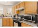 Well-lit kitchen with wooden cabinets, stone countertops and appliances at 5674 Moccasin Point St, Las Vegas, NV 89148