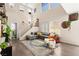 Bright, open living room featuring a staircase, hardwood floors, and large windows at 5674 Moccasin Point St, Las Vegas, NV 89148