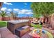 A secluded backyard featuring a hot tub, lounging area, and artificial turf at 6187 Novelty St, Las Vegas, NV 89148