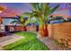 Lush backyard with mature palm trees, a block wall, and synthetic grass, perfect for outdoor enjoyment at 6187 Novelty St, Las Vegas, NV 89148