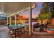 A charming backyard patio with a dining table, hot tub, and seating area creates an ideal space for outdoor living at 6187 Novelty St, Las Vegas, NV 89148