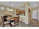 Open-concept dining area with modern lighting, wood table, and access to the kitchen at 6187 Novelty St, Las Vegas, NV 89148