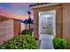 Inviting home entrance with security gate, lush bushes, and neutral exterior paint at 6187 Novelty St, Las Vegas, NV 89148