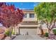 Charming two-story house boasts a two-car garage and beautiful landscaping with vibrant, mature trees at 6187 Novelty St, Las Vegas, NV 89148