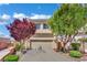 Two-story home featuring a two-car garage, mature trees, and well-maintained landscaping for curb appeal at 6187 Novelty St, Las Vegas, NV 89148