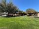 Beautiful front lawn with lush green grass and mature trees at 6187 Novelty St, Las Vegas, NV 89148