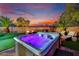 Relax and unwind in this backyard hot tub with colorful sunset views and lush, landscaped surroundings at 6187 Novelty St, Las Vegas, NV 89148