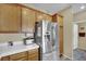 Modern stainless steel refrigerator in a kitchen with white countertops and wooden cabinets at 6187 Novelty St, Las Vegas, NV 89148