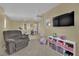 Open living space with a TV, gray recliner, and neutral colored carpet at 6187 Novelty St, Las Vegas, NV 89148