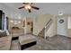 Inviting living room featuring a sectional sofa, ceiling fan, staircase and open-concept design at 6187 Novelty St, Las Vegas, NV 89148