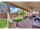 Covered patio with ample seating overlooks the backyard with its play area and hot tub at 6187 Novelty St, Las Vegas, NV 89148