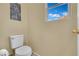 Picture of a toilet in a half bathroom with tile flooring and a window at 6187 Novelty St, Las Vegas, NV 89148