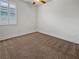 A bedroom with carpet, a ceiling fan, and a window with plantation shutters at 6312 Conlon St, North Las Vegas, NV 89081