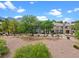 Exterior view of a townhome with mature trees and desert landscaping at 664 Peachy Canyon Cir # 103, Las Vegas, NV 89144