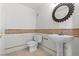 Compact powder room featuring a pedestal sink, toilet, and decorative mirror at 664 Peachy Canyon Cir # 103, Las Vegas, NV 89144