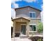 Charming two-story home with a covered porch and neutral stucco exterior under a partly cloudy sky at 7411 Sunray Point St, North Las Vegas, NV 89084