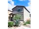 Two story home with desert landscaping and partial view of the side yard and the covered entryway at 7411 Sunray Point St, North Las Vegas, NV 89084