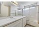 Bathroom featuring dual sinks and a shower-tub combo with sliding glass doors at 7521 Reindeer Ct, Las Vegas, NV 89147