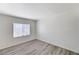 Cozy bedroom with wood-look flooring and a large window providing ample natural light at 7521 Reindeer Ct, Las Vegas, NV 89147
