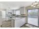 Updated kitchen with white cabinets, a peninsula, stainless appliances, and outdoor access at 7521 Reindeer Ct, Las Vegas, NV 89147