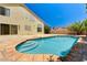 Backyard pool with stone surround, steps, and a house with a stucco exterior at 7521 Reindeer Ct, Las Vegas, NV 89147
